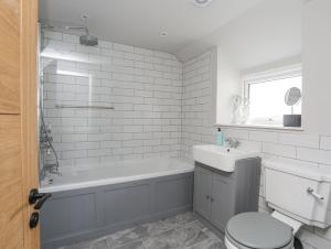 a bathroom with a tub and a toilet and a sink at Ty Bara in Cemaes Bay +59 photos