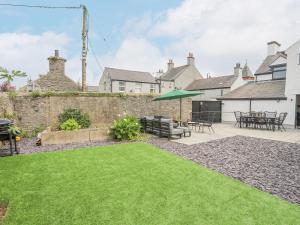 a garden with a patio and a lawn at Ty Bara in Cemaes Bay
