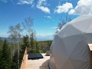 ein großes weißes Zelt auf einer Holzterrasse in der Unterkunft Nørdika Charlevoix in Baie-Saint-Paul
