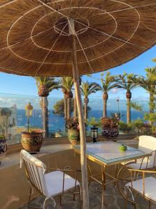 een tafel en stoelen onder een parasol op een patio bij 2 Bedrooms 1 Bathrooms-2 Pools&With Direct beach Access in Tanger