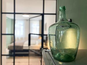 a green glass bottle sitting on top of a table at WEINQUARTIER Weingarten Loft 70 qm 2 SZ Altstadt Balkon Himmelbett Küche Parkplatz in Naumburg