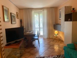 a living room with a television and a table with a desk at CASA VACANZA LA TERRAZZA in Valbrona