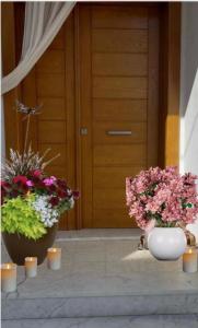 two vases filled with flowers in front of a door at Residence Amira in Monastir