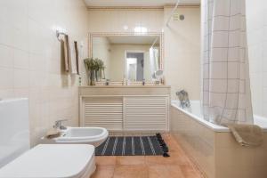 a bathroom with a sink and a toilet and a mirror at Sun & Sea Golf House in Aroeira +41 photos