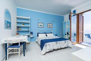 ein blaues Schlafzimmer mit einem Bett und einem Schreibtisch in der Unterkunft Casa Jole in Amalfi