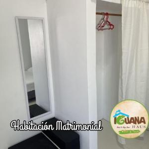 La salle de bains est pourvue d'un miroir mural blanc. dans l'établissement IGUANA HAUS IQUITOS, à Iquitos