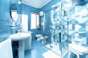 ein blaues Bad mit einem Waschbecken, einem WC und einer Dusche in der Unterkunft Casa Jole in Amalfi