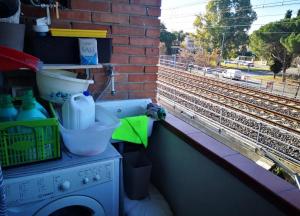 Una lavadora colocada en una repisa junto a una vía de tren en Casa Camilla, en Grosseto