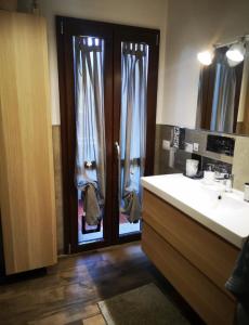 Un baño con una puerta con lavabo y espejo. en Casa Camilla, en Grosseto