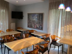 comedor con mesas y sillas y TV en Alexandros, en Kamena Vourla