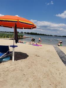 a beach with an umbrella and people in the water at Sailor Apart Okuninka in Okuninka
