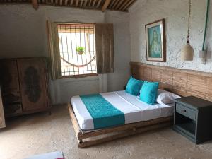 Un dormitorio con una cama con almohadas azules y una ventana. en Cabañas rurales Arabi, en Pereira