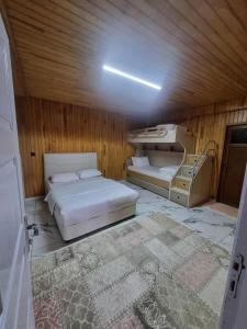 een kleine slaapkamer met 2 bedden en een tapijt bij Özkan Apart in Çaykara