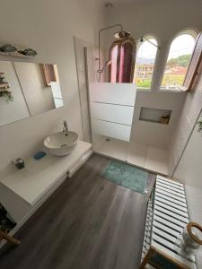 a bathroom with a sink and a mirror at chez steph in La Trinité