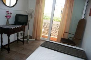Dormitorio con cama, escritorio y TV en Hostal Yebisah, en Santa Eulària des Riu