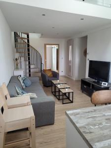 a living room with a couch and a tv at La Rivière Appartement proche mer et centre de Wimereux in Wimereux