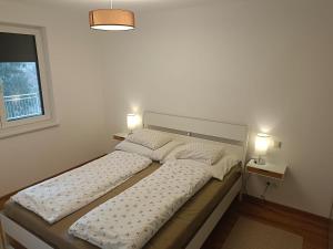 two beds in a room with two lamps on them at Salzkammergut View in St. Wolfgang