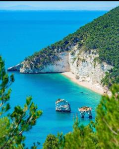 twee boten in het water naast een strand bij Appartamento Gargano in Carpino