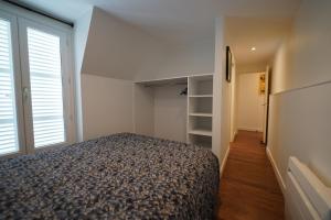a bedroom with a bed and a large window at Appartement de Paul in Aurillac
