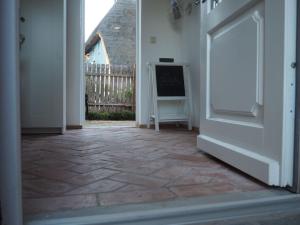 una puerta abierta a una habitación con suelo de piedra en Dwargenhus, en Prerow