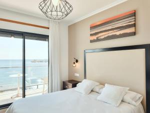 a bedroom with a bed with a view of the ocean at Hotel Mardevela in Sanxenxo
