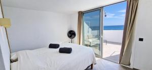 1 dormitorio con 1 cama y balcón con vistas al océano en MAR a 9 Las Playitas, en Las Playitas