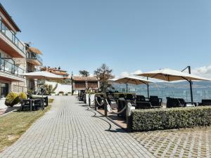un trottoir avec des tables, des chaises et des parasols dans l'établissement Hotel Mardevela, à Sanxenxo