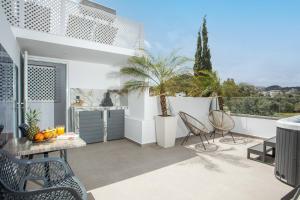a patio with chairs and a table on a balcony at JnS Premium Stay in Faliraki