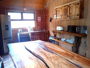 cocina con cama grande de madera en una habitación en Mi Refugio del Sur, en Licán Ray