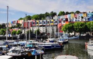 a group of boats docked in a marina with colorful buildings at Huller and cheese warehouse apartments in Bristol