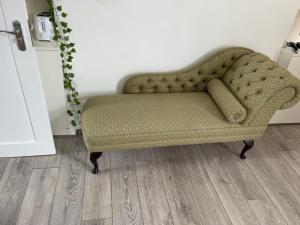 a green couch in a room with a wooden floor at RSB Inn London in London