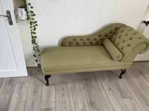 a green couch in a room with a wooden floor at London Budget Bliss, London W12, white city, shepherd's bush market in London