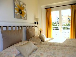 um quarto com uma cama e uma janela em Hostal Yebisah em Santa Eulària des Riu