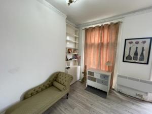 a living room with a couch and a window at London Budget Bliss, London W12, white city, shepherd's bush market in London +34 photos