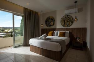 a bedroom with a large bed and a balcony at JnS Premium Stay in Faliraki +110 photos