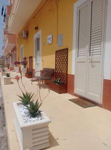a porch of a building with a bench and flowers at Victoria apartments in Lampedusa