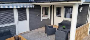 Casa con terraza de madera con silla en Hus i flott natur., en Skjåk
