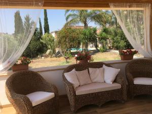 two wicker chairs sitting on a porch with a window at Agriturismo Adenzia in Porto Empedocle