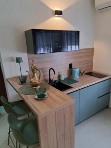 a kitchen with a counter with a sink and a table at RUBIS SUITE in Mostar