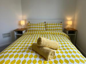 una camera con un letto giallo e bianco con due lampade di Urban Escape Entire Apartment Near Uni and Hospital a Southampton