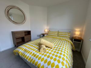 a bedroom with a yellow and white bed with a mirror at Urban Escape Entire Apartment Near Uni and Hospital in Southampton