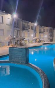 uma vista para uma piscina à noite em Appartement El jadida Sidi Bouzid em Sidi Bouzid