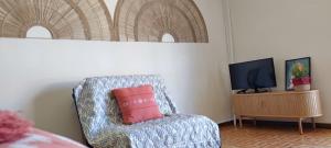 een kamer met een stoel met een roze kussen erop bij Casa Golfinho (Norte) - Costa Nova in Costa Nova