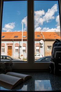 un livre ouvert sur une fenêtre avec vue sur un bâtiment dans l'établissement Apartman Agata,Osijek, self check-in, à Osijek