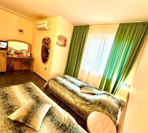 ein Hotelzimmer mit 2 Betten und einem Fenster in der Unterkunft Hotel Color in Warna