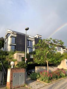 a rainbow in front of a house with a car at Fancy Loft mit Traumblick in Leonberg