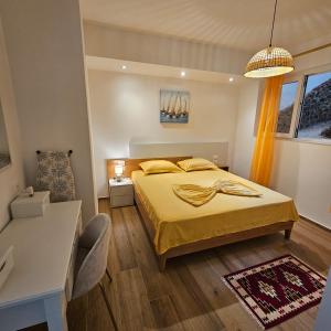 a bedroom with a bed with yellow sheets and a window at Blue Horizon 1 in Vlorë
