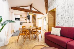 a living room with a table and a red couch at Élégance Rochelaise avec Terrasse in La Rochelle +25 photos