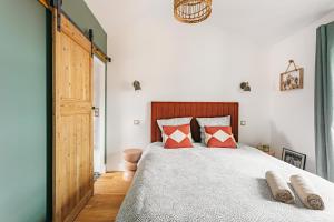 a bedroom with a large bed with red pillows at Élégance Rochelaise avec Terrasse in La Rochelle