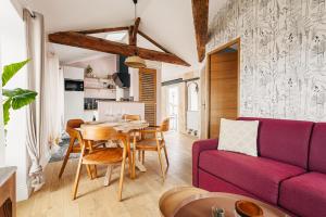 a living room with a purple couch and a table at Élégance Rochelaise avec Terrasse in La Rochelle